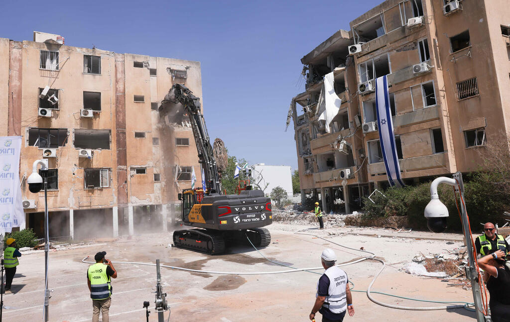  הרס הבתים שנפגעו בחולון. מלתעות הדינוזאור כרסמו בבניין וחשפו חדרים מלאים ברהיטים וחפצים אישיים שנפלו למטה 