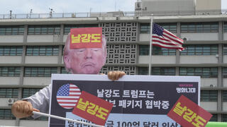 מפגין נגד מדיניות ה מכסים של דונלד טראמפ ליד שגרירות ארה"ב ב סיאול דרום קוריאה 30.7.25