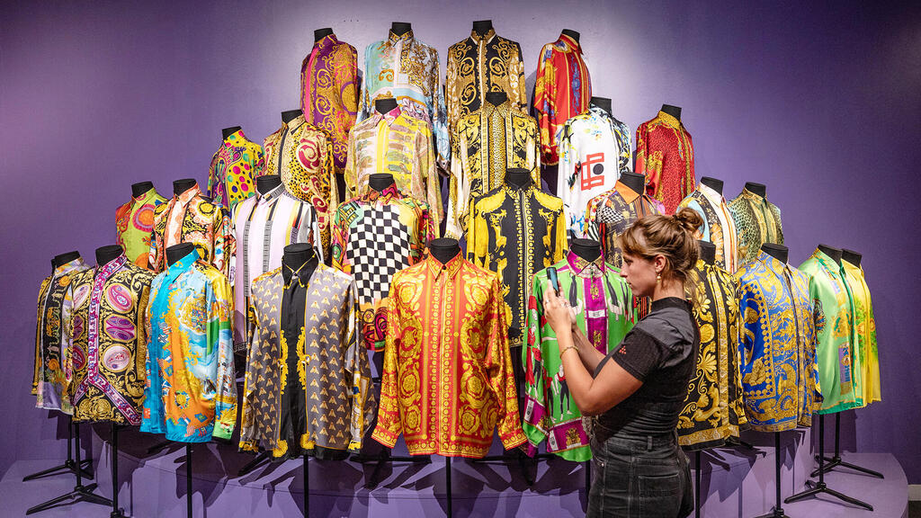 חולצות משי צבעוניות בעיצוב ורסאצ'ה המוצגות בתערוכה. מהמעצבים הראשונים ששילבו אופנה ופופ (צילום: Justin Sutcliffe) חולצות משי צבעוניות בעיצוב ורסאצ'ה המוצגות בתערוכה לבית האופנה פנאי