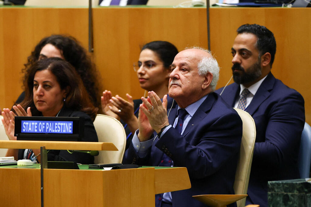 הנציג הפלסטיני באו"ם ריאד מנסור מוחא כפיםם למקרון (צילום: Angela WEISS / AFP) הנציג הפלסטיני באו"ם ריאד מנסור בעצרת בה הכירה צרפת ב מדינה פלסטינית 23.9.25