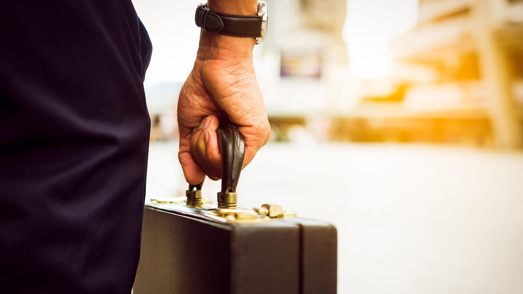 (אילוסטרציה) (צילום: Chay Tee/Shutterstock) איש עסקים נושא מזוודה נסיעה תיירות אילוסטרציה
