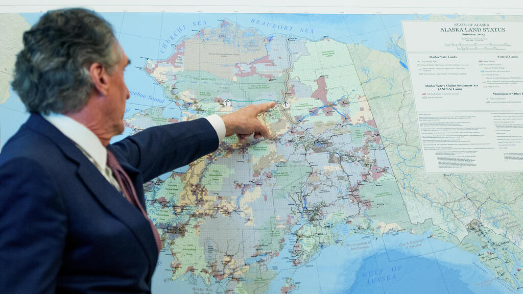 דאג בורגום , שר הפנים של ארה"ב, מציג מפה של אלסקה במסיבת עיתונאים עם טראמפ בבית הלבן הממשל ביטל את החלטת ממשל ביידן לעצור את בניית פרויקט אמבלר רואד באלסקה 6.10.25