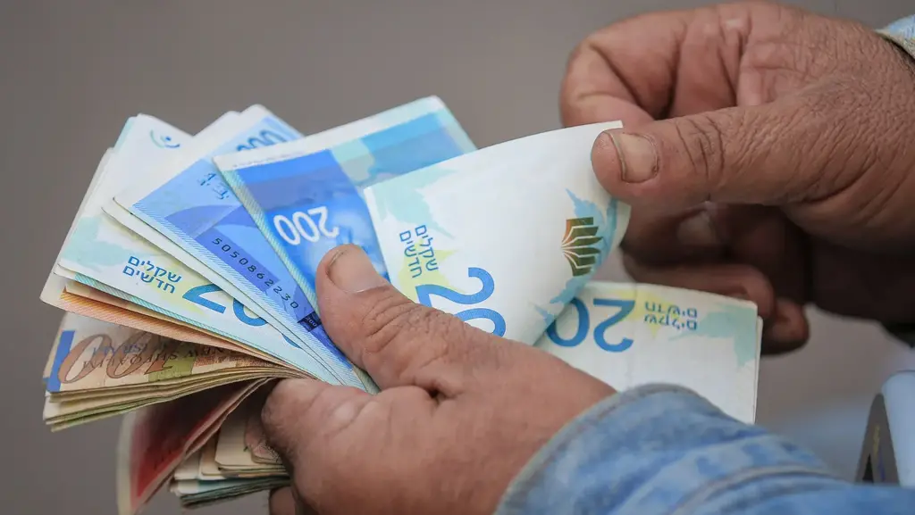 השווקים מתמחרים תרחיש של סוף מלחמה (צילום: Ahmad Salem/Bloomberg) שקלים שקל שטרות כסף