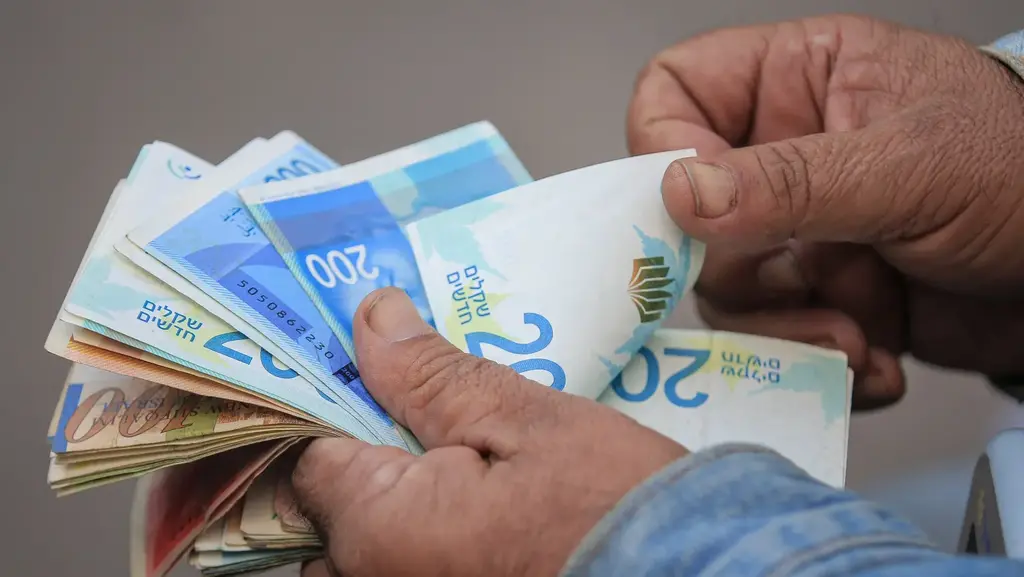 התחזקות של יותר מ-8% מול הדולר (צילום: Ahmad Salem/Bloomberg) שקלים שקל שטרות כסף