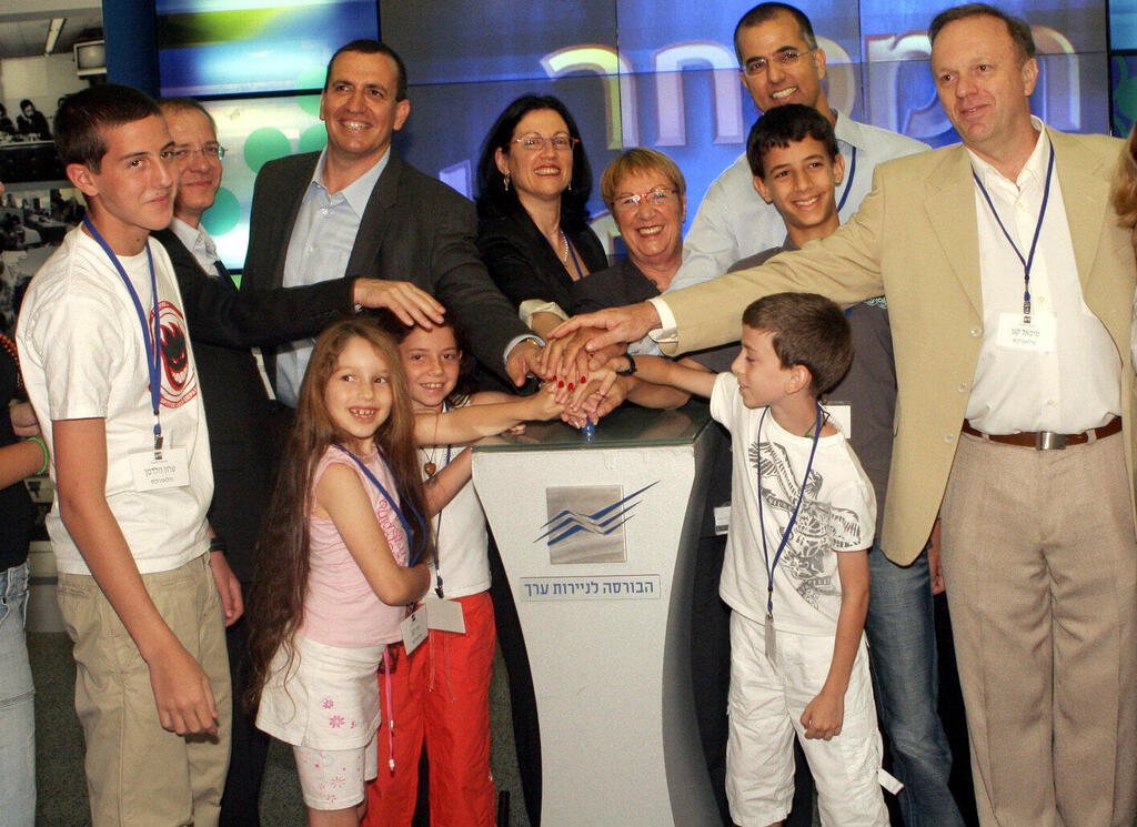 Kagan <span style="font-weight: normal;">(right),</span> Waldman <span style="font-weight: normal;">(second from left)</span> with Mellanox executives and their children at the opening of trading on the stock exchange in 2007. (Yisrael Malovni) כגן )מימין(, וולדמן )שני משמאל( עם בכירי מלאנוקס וכמה מילדיהם בפתיחת המסחר בבורסה ב־ 2007 .
