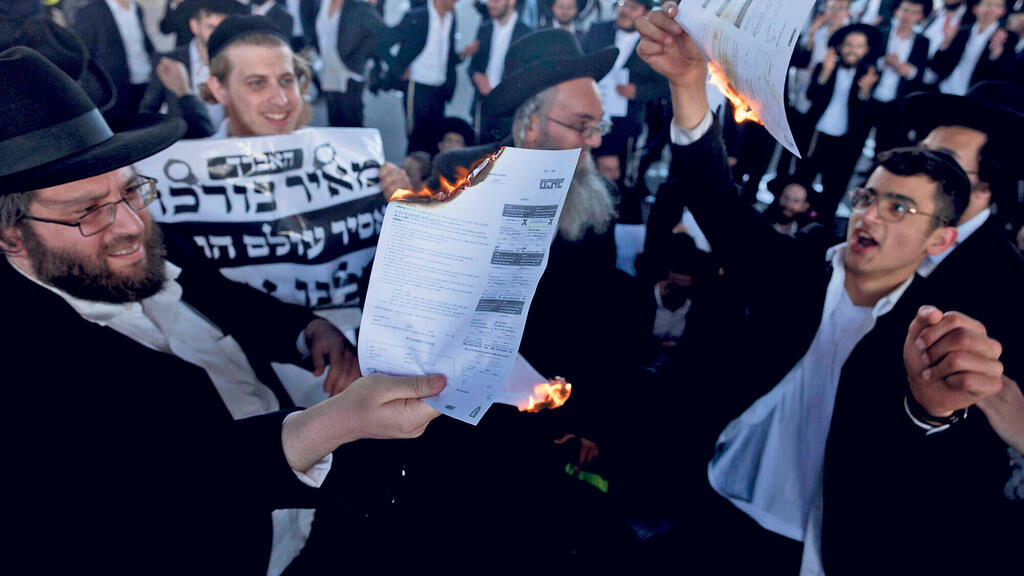 חרדים שורפים צווי גיוס בהפגנה בנובמבר (צילום: Amir Levy /Getty Images) צעירים חרדים שורפים צווי גיוס צו גיוס