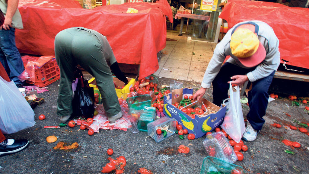 איסוף מזון בשוק הכרמל בתל אביב. 39% מהמזון המיוצר בארץ נזרק ב־2024 (צילום: מיכאל קרמר) איסוף מזון אשפה שוק הכרמל בתל אביב