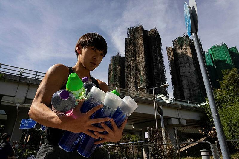 מתנדב באיזור השריפה בהונג קונג מחלק ציוד בסיסי לנפגעים (צילום: AP Photo/Chan Long Hei) מתנדב באיזור השריפה בהונג קונג מחלק ציוד בסיסי לנפגעים