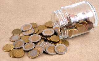 כסף מתוך צנצנת מטבעות חיסכון פנסיה