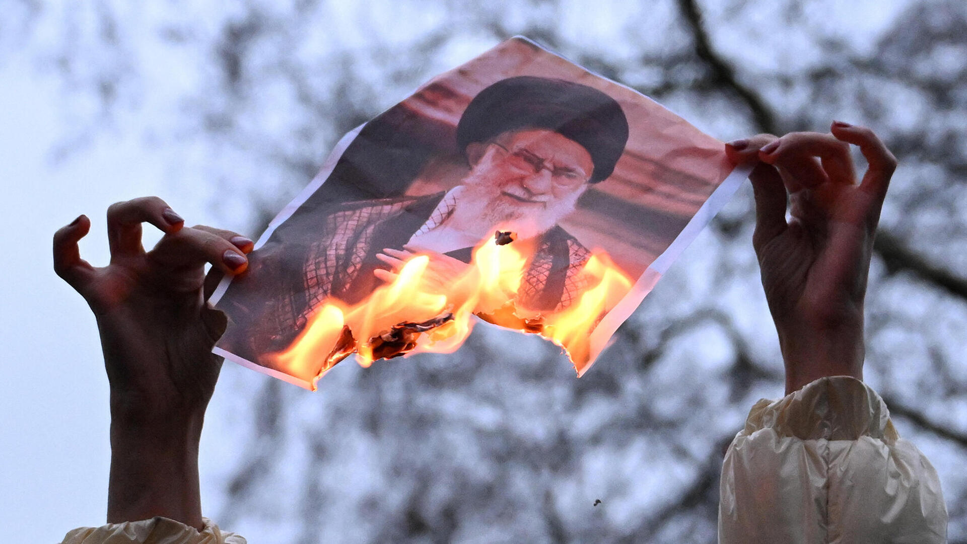 פוטו הפגנות מהפכה איראן לונדון שורפים תמונה של חמינאי