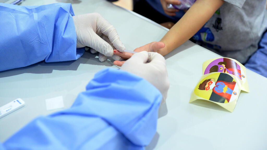 חיילים של פיקוד העורף מבצעים בדיקת דם לילדים