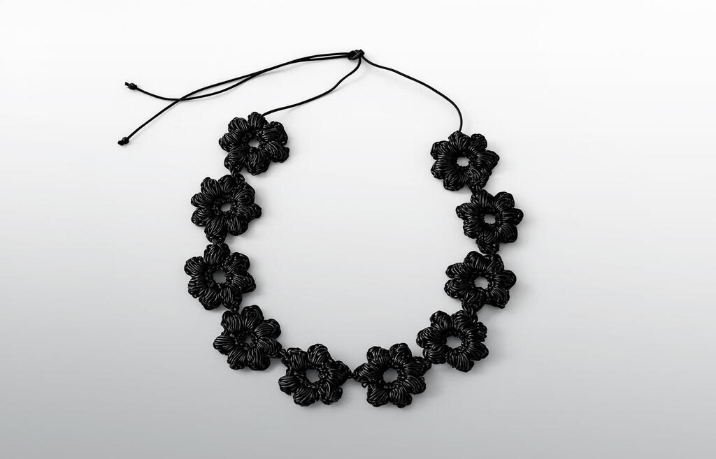 חגורת פרחים סרוגה בעבודת יד מחוטי עור שחורים בעיצוב טל טרילניק פנאי