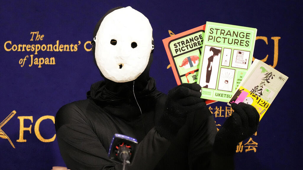 אוקטסו עם ספריו. "הבנתי שהמראה שלי יכול להועיל לדברים שאני יוצר" (צילום: Koji Watanabe/Getty Images) אוקטסו - יוטיובר וסופר יפני פנאי