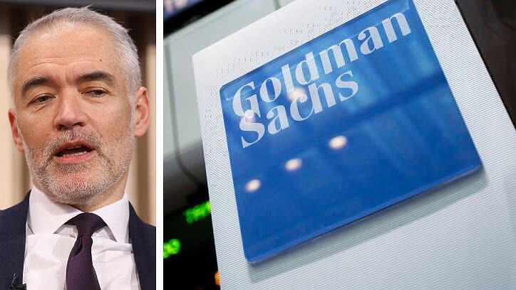 אנטוני גוטמן לצד שלט גולדמן זאקס בית השקעות