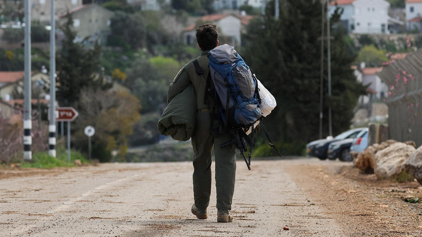 מלחמה מול חיזבאללה חייל מילואים צועד בכניסה לישוב בגבול הצפון ב אצבע הגליל
