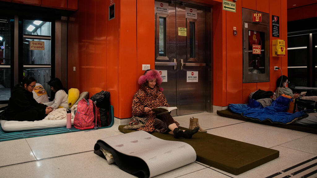 אזרחים לנים בתחנת רכבת קלה ב תל אביב מלחמה עם איראן