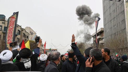 Protest against Israel in Tehran against the backdrop of an explosion from an Israeli attack, earlier this month.