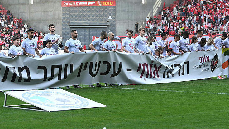 שחקני הפועל באר שבע עם שלט וחולצות מחווה לילדים אוטיסטים אוטיזם פברואר 2025