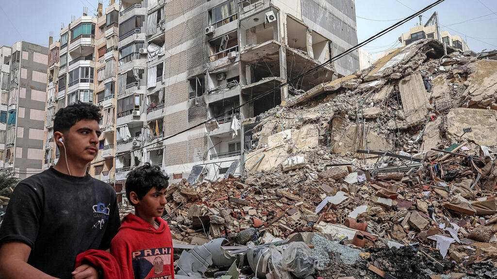 תושבים בשכונת הדאחייה לבנון ביירות אתמול ליד ההרס מהפצצה של צה"ל