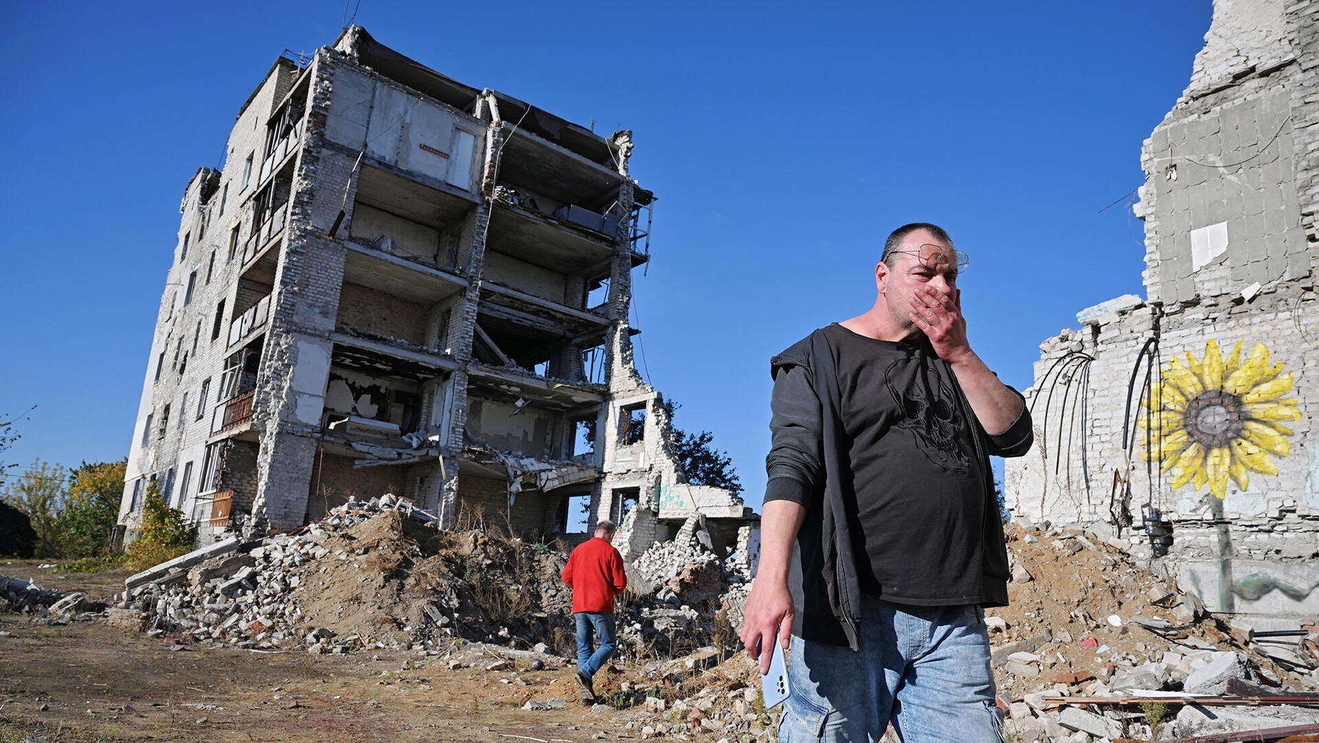 איבו ניקולא תומך פוטין ליד בניין שהופגז באוקראינה מתוך הסרט Change My Min פנאי