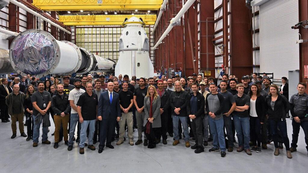 עובדי ספייס X (צילום: SpaceX) עובדי ספייס X ליד רקטת פלקון 9 והחללית דראגון