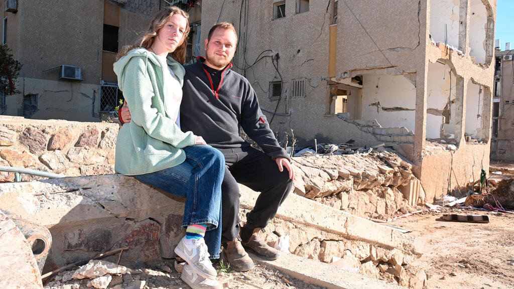 רוני וקסלמן וליזה רוגצ'בסקי ליד הבניין שלהם שנפגע במלחמה (צילום: הרצל יוסף) החיים אחר ההרס רוני וקסלמן ליזה רוגצ'בסקי - זוג שביתם נפגע מפגיעת טיל מאיראן