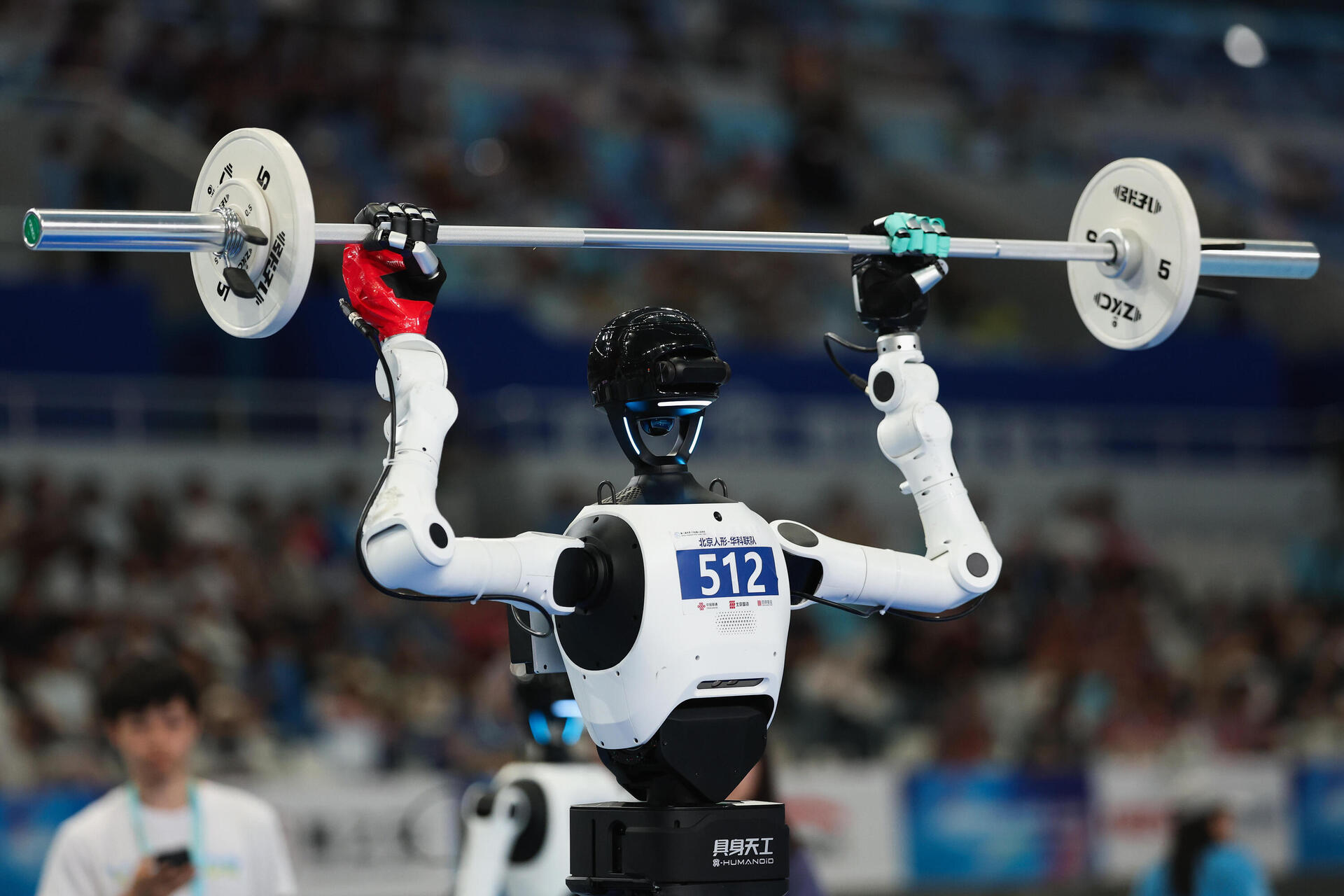 BEIJING, CHINA - AUGUST 24: Humanoid robots competes in the weightlifting event during the 2nd World Humanoid Robot Games at National Speed Skating Oval on August 24, 2026 in Beijing, China. The second World Robot Games will be held in Beijing from August 22nd to 26th.  (Photo by Lintao Zhang/Getty Images) 