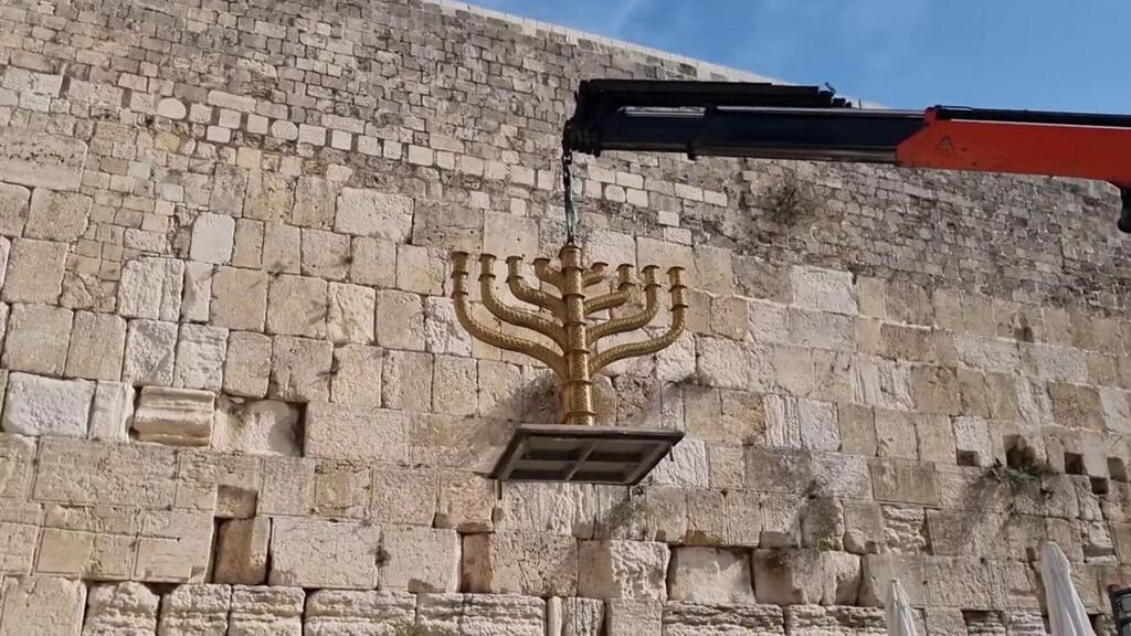 החנוכיה של אדם בראון שמוצבת מידי שנה בכותל (צילום: מתוך ערוץ היוטיוב של הקרן למורשת הכותל ) החנוכיה של אדם בראון שמוצבת מידי שנה בכותל