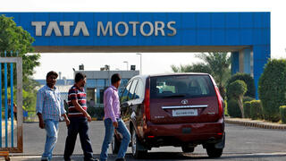 FILE PHOTO: FILE PHOTO: A vehicle drives past three men walking out of a Tata Motors car plant at Sanand in the western Indian state of Gujarat, India, October 27, 2016. REUTERS/Amit Dave/File Photo/File Photo 