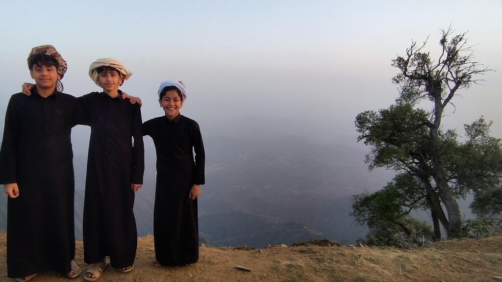 Three youths in the mountains of the Asir region, on the border with Yemen. (Aviad Sar-shalom) שלושה נערים בהרים של מחוז עסיר, על גבול תימן. “אף אחד לא אוהב את החות’ים”, אמר מוכר הקפה שטוען שהוא מצנעא, “הם ייפלו מתישהו”