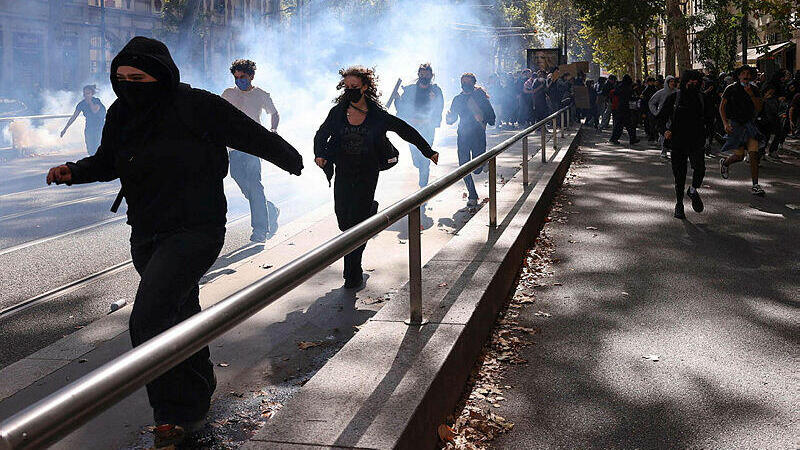 מפגינים בליון, צרפת, בורחים לאחר שהמשטרה פיזרה גז מדמיע (צילום: Alex MARTIN / AFP) מפגינים בליון, צרפת, בורחים לאחר שהמשטרה פיזרה גז מדמיע