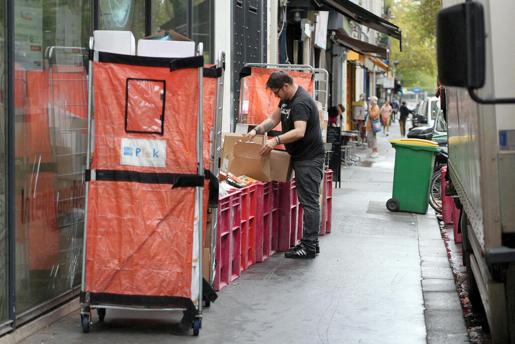 A worker throws away food at an Intermarché branch. They didn’t take any chances. (Photo: Lucien Libert/Reuters) עובד משליך מזון בסניף של אינטרמרשה