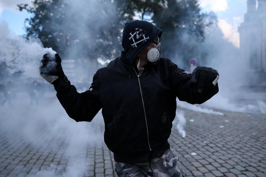 מפגין עם מסיכת גז בנאנט (צילום: REUTERS) A protester prepares to throws a tear gas cannister during a demonstration as part of nationwide protests called by the "Yellow Vests" movement against the cost of living and rising fuel prices, joined by French high school and university students, teachers and parents demanding better school conditions and government action, as well as labour unions, workers, farmers and retirees, in Nantes,…