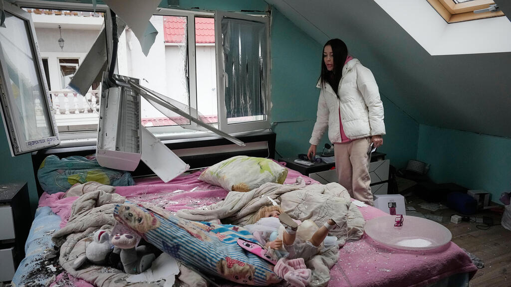 A woman looks at her damaged apartment after a Russian missile attack in Kyiv, Ukraine, Thursday, Oct. 22, 2026. (AP Photo/Efrem Lukatsky) 