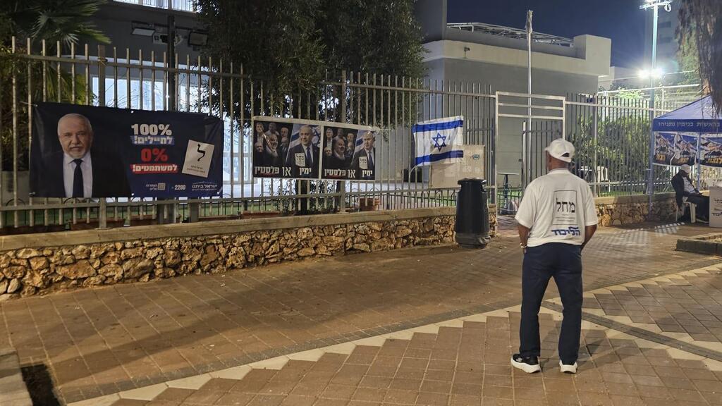 הכניסה למתנ"ס בנתניה. עמדה של הליכוד ושלטי "ימין או פלסטין" לצד שלט של ליברמן וההבטחה ל-"100% לחיילים" (צילום: עמיר קורץ) הכניסה למתנ"ס בנתניה